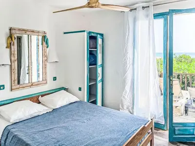 a bedroom with a blue bed and a balcony at Holiday Home Casa Blue by Interhome in Sainte-Lucie de Porto-Vecchio