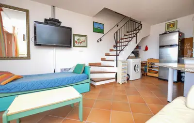 a living room with a couch and a tv at Villa Piscine Vue Mer in Porto-Vecchio