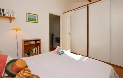 a bedroom with a white bed with a large sliding door at Villa Piscine Vue Mer in Porto-Vecchio