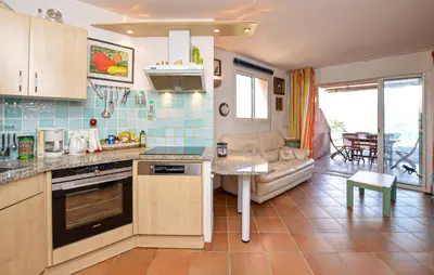 a kitchen and living room with a couch and a table at Villa Piscine Vue Mer in Porto-Vecchio