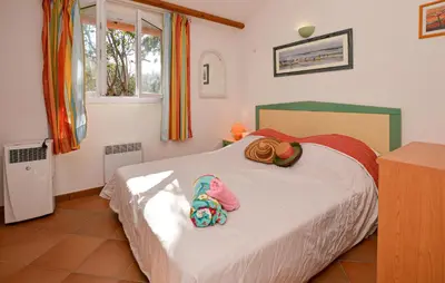 a bedroom with a bed with hats and flip flops on it at Villa Piscine Vue Mer in Porto-Vecchio