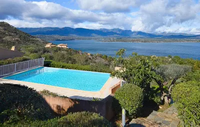 a swimming pool with a view of a body of water at Villa Piscine Vue Mer in Porto-Vecchio