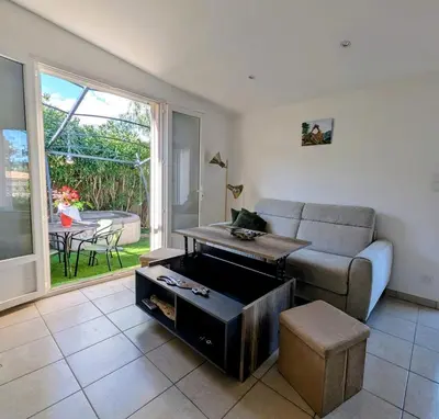 a living room with a couch and a table at charmante maisonnette avec spa privatif in Zonza