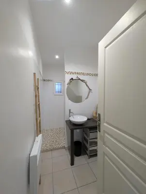 a white bathroom with a sink and a mirror at charmante maisonnette avec spa privatif in Zonza