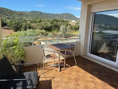 a patio with a table and chairs on a balcony at Appartement lumineux à Ajaccio 2 chambres in Ajaccio