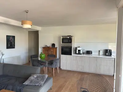 a living room with a couch and a kitchen at Appartement lumineux à Ajaccio 2 chambres in Ajaccio