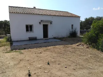 a white building with a bench in front of it at villa au calme à Figari in Figari