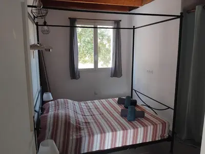 a bedroom with a canopy bed with a window at villa au calme à Figari in Figari