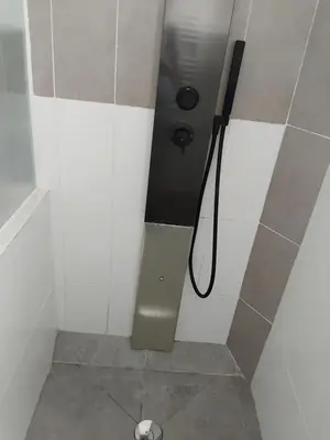 a bathroom with a shower stall with a hose at villa au calme à Figari in Figari