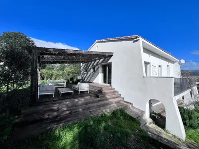 a white house with a wooden deck with a patio at Belle maison 4 chambres proche du centre ville et des plages in Ajaccio