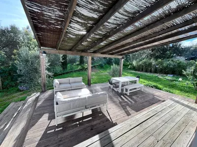 a wooden deck with two couches and a pergola at Belle maison 4 chambres proche du centre ville et des plages in Ajaccio
