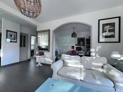 a living room with a white couch and a table at Belle maison 4 chambres proche du centre ville et des plages in Ajaccio