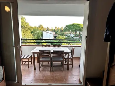 a dining room table and chairs on a balcony at Appartement avec piscine en Costa Verde in San-Nicolao