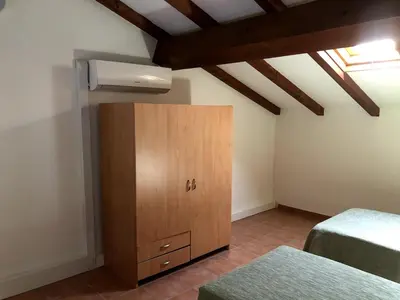 a bedroom with two beds and a wooden cabinet at Appartement avec piscine en Costa Verde in San-Nicolao