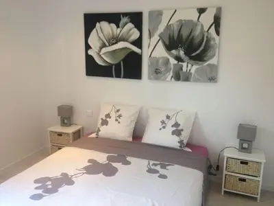 a bedroom with a bed with two pictures on the wall at AJACCIO Hyper centre Fesch in Ajaccio