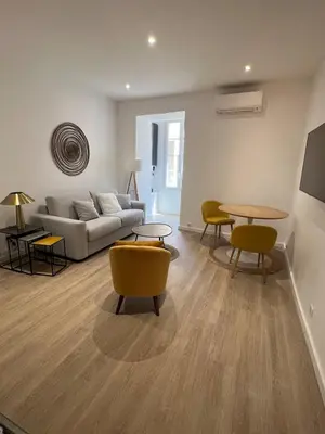 a living room with a couch and a table and chairs at AJACCIO Hyper centre Fesch in Ajaccio