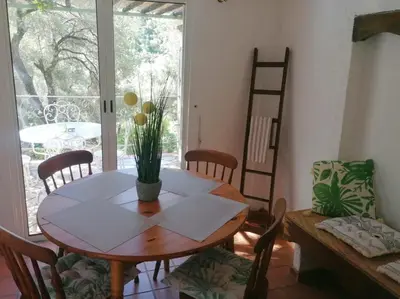 a dining room with a table and chairs and a window at La licorne in Serriera
