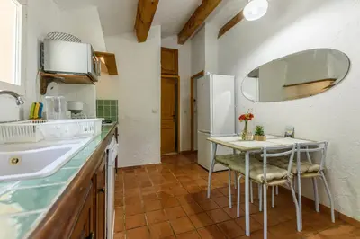 a kitchen with a table and a white refrigerator at La licorne in Serriera