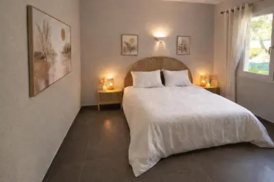 a bedroom with a large white bed with two tables at Le Scudo in Ajaccio