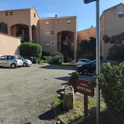 a street sign in a parking lot with cars parked at Le Scudo in Ajaccio