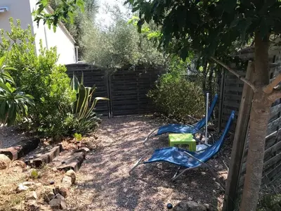 a yard with two lawn chairs and a fence at Charmants studios in Afa