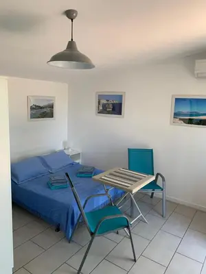 a bedroom with a bed and a table and chairs at Charmants studios in Afa