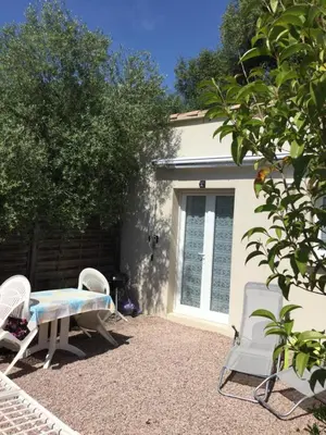 a patio with a table and chairs in front of a house at Charmants studios in Afa