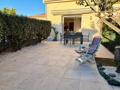 a patio with two chairs and a table in a yard at Charmant Duplex proche mer, Clim Terrasse à BORGO in Borgo