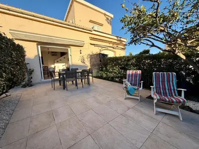 a patio with chairs and a table and a house at Charmant Duplex proche mer, Clim Terrasse à BORGO in Borgo