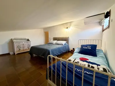 a bedroom with two beds and a dresser at Charmant Duplex proche mer, Clim Terrasse à BORGO in Borgo