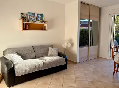 a living room with a couch and a sliding glass door at Charmant Duplex proche mer, Clim Terrasse à BORGO in Borgo