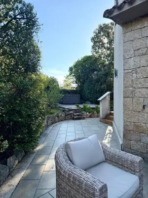 a wicker couch sitting on a patio at Villa en pierre Vue imprenable sur le Golfe in Propriano