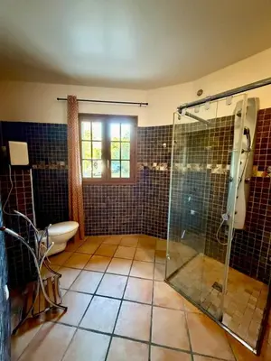 a bathroom with a glass shower and a toilet at Villa en pierre Vue imprenable sur le Golfe in Propriano