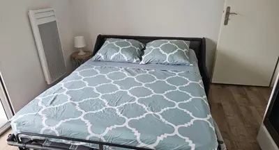 a bedroom with a bed with blue sheets and pillows at Studio 2 minutes du port Bonifacio avec parking privé in Bonifacio