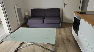 a living room with a couch and a table at Studio 2 minutes du port Bonifacio avec parking privé in Bonifacio