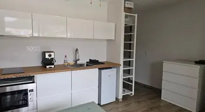 a kitchen with white cabinets and a sink at Studio 2 minutes du port Bonifacio avec parking privé in Bonifacio