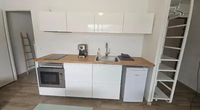a kitchen with a sink and a microwave at Studio 2 minutes du port Bonifacio avec parking privé in Bonifacio