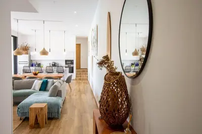 a living room with a couch and a mirror at Villa MIASULI, Domaine privé, Piscine chauffée, À 10 min de la plage in Sainte-Lucie de Porto-Vecchio