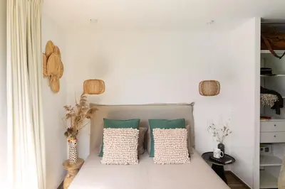 a bedroom with a bed with green and white pillows at Villa MIASULI, Domaine privé, Piscine chauffée, À 10 min de la plage in Sainte-Lucie de Porto-Vecchio