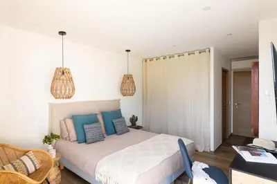 a bedroom with a large bed with blue pillows at Villa MIASULI, Domaine privé, Piscine chauffée, À 10 min de la plage in Sainte-Lucie de Porto-Vecchio