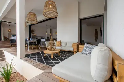a living room with a couch and a table at Villa MIASULI, Domaine privé, Piscine chauffée, À 10 min de la plage in Sainte-Lucie de Porto-Vecchio