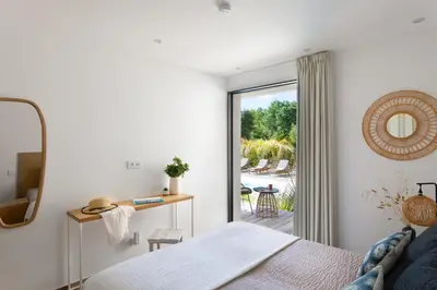 a bedroom with a bed and a sliding glass door at Villa MIASULI, Domaine privé, Piscine chauffée, À 10 min de la plage in Sainte-Lucie de Porto-Vecchio