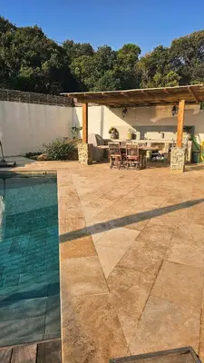 a patio with a table and chairs and a pool at Villa Pinarello, Piscine et Mer in Zonza