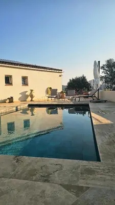 a swimming pool in front of a house at Villa Pinarello, Piscine et Mer in Zonza