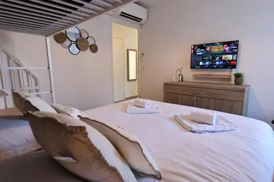 a bedroom with a bed with two pillows and a tv at Villa Monte Leone - 2 Piscines Bonifacio in Bonifacio