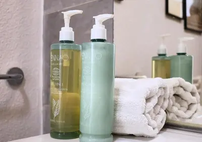 two bottles of liquid soap and a mirror in a bathroom at Villa Monte Leone - 2 Piscines Bonifacio in Bonifacio