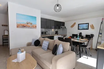 a living room and kitchen with a couch and a table at Villa Monte Leone - 2 Piscines Bonifacio in Bonifacio