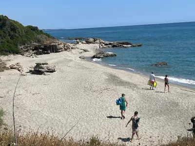 a group of people walking on the beach at Chioselle in Chiatra