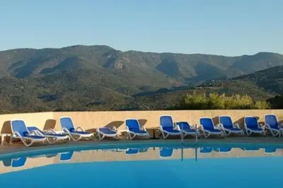 a row of chairs sitting next to a swimming pool at Sublime Appartement neuf climatisé vue imprenable sur la mer terrasse wifi in Serra-di-Ferro
