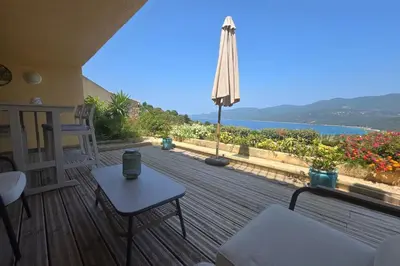 a wooden deck with a view of the water at Sublime Appartement neuf climatisé vue imprenable sur la mer terrasse wifi in Serra-di-Ferro